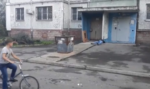 Во дворе дома лежит труп, дети снимают видео